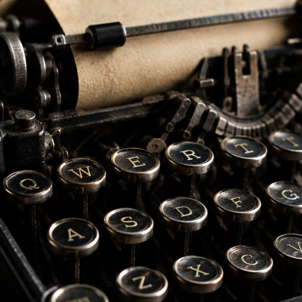 Close-up of vintage typewriter keys with a sheet of paper